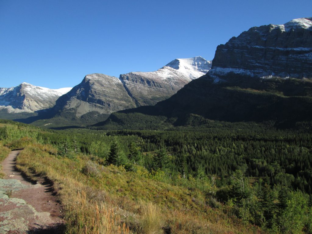 Dirt path with a backdrop of valleys and mountains, illustrating the path less traveled to financial freedom that this blog represents.