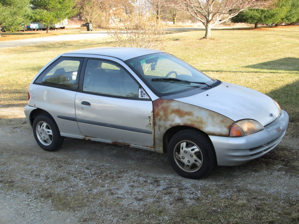 A beat-up silver Chevy Metro with no power steering, cruise control, or power options. Truly basic transportation illustrating the humble beginnings of the author and his wife at the time they were married.