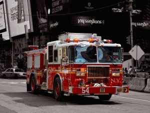 A NYC fire engine streaking down a street with lights ablaze, en route to a call. The photo illustrates how Mint is standing by to come to your bill pay rescue.