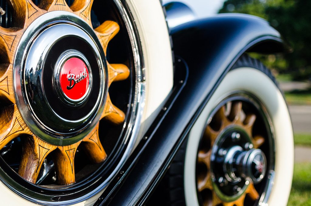 A close-up of a fender-mounted spare tire on a classic early 20th-century car, illustrating a surprising side effect of an emergency fund.