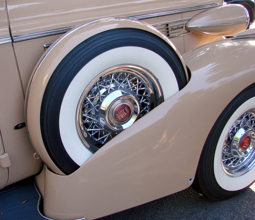 A close-up of a fender-mounted spare tire on a classic 1938 Buick, illustrating the need to pack your emergency fund spare tire.