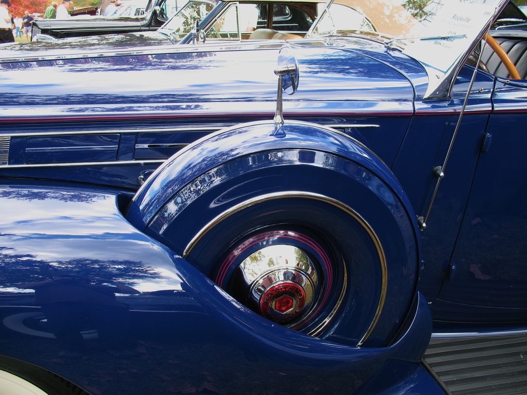 A close-up of a fender-mounted spare tire on a classic 1938 Packard, illustrating care necessary to store your emergency fund appropriately.