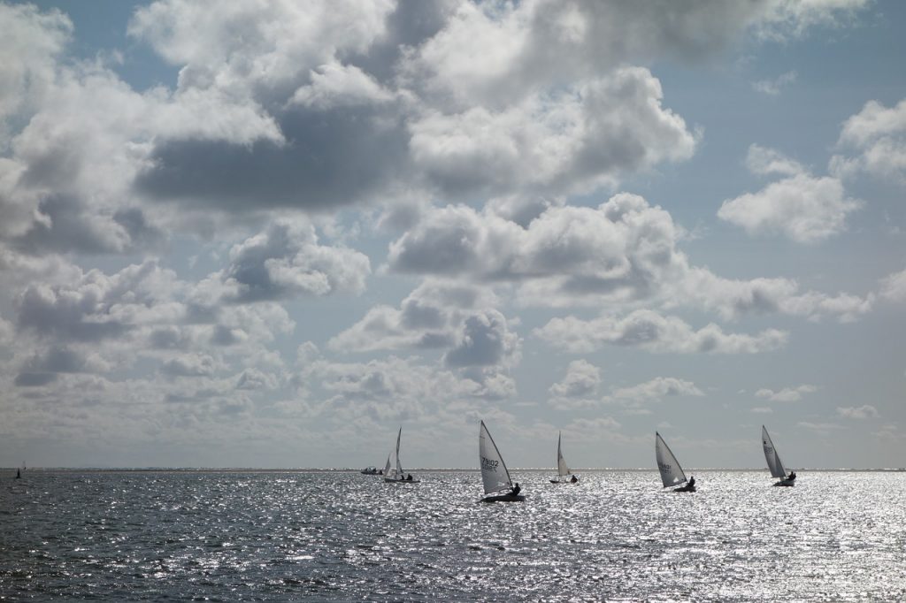 Five sailboats harnessing the power of the wind, illustrating how you can harness the five benefits of automatic bill pay. 