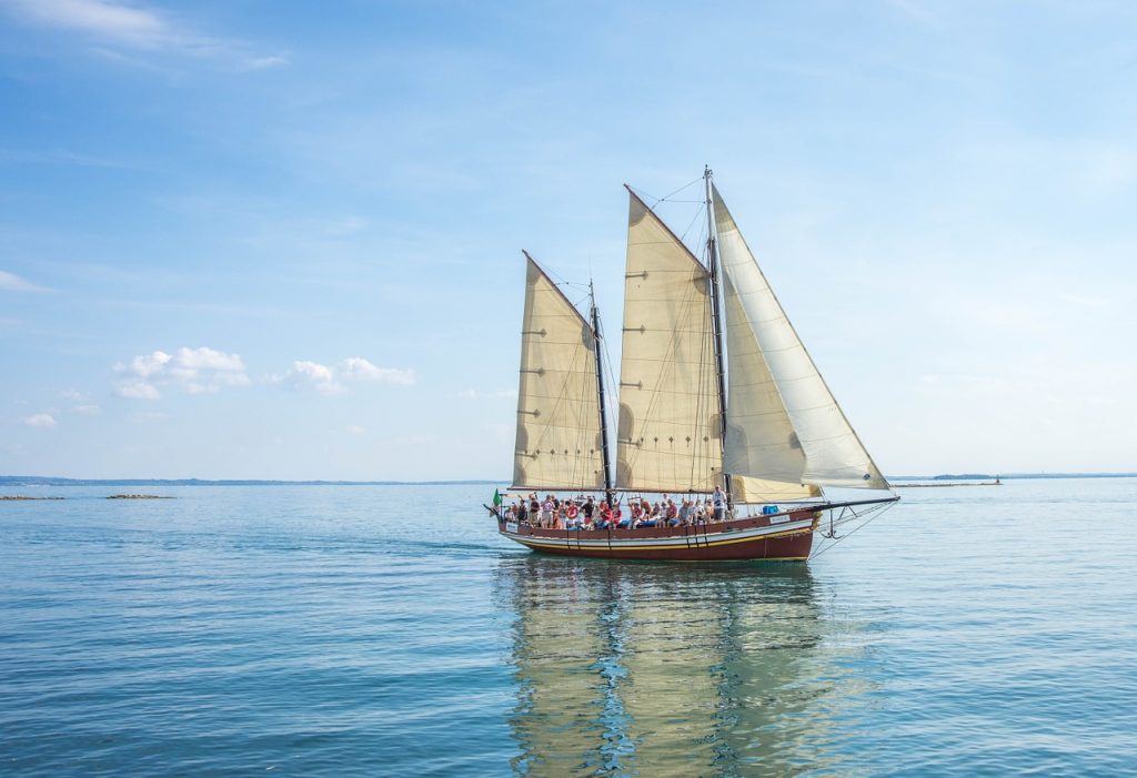 An overcrowded sailboat, illustrating the potential risks of automatic bill pay.