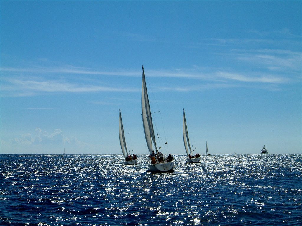 Three sailboats sailing together, illustrating the three unique risk/reward levels of automatic bill pay.