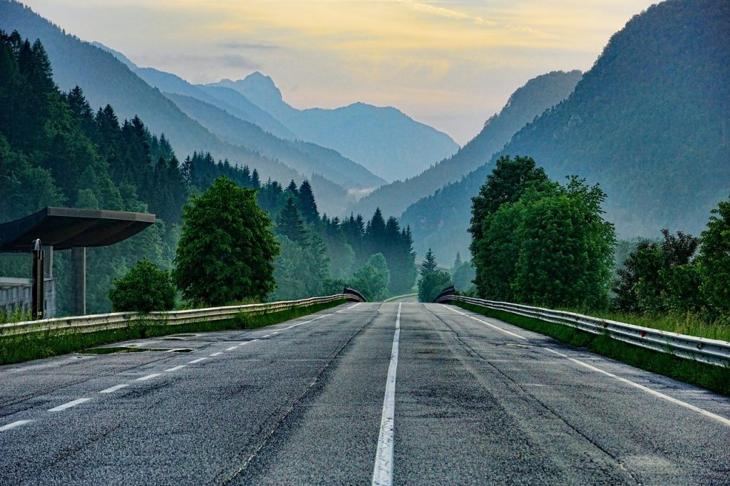 A road leading up into the mountains, illustrating the importance of facing your fears and climbing your money mountain to obtain financial freedom.